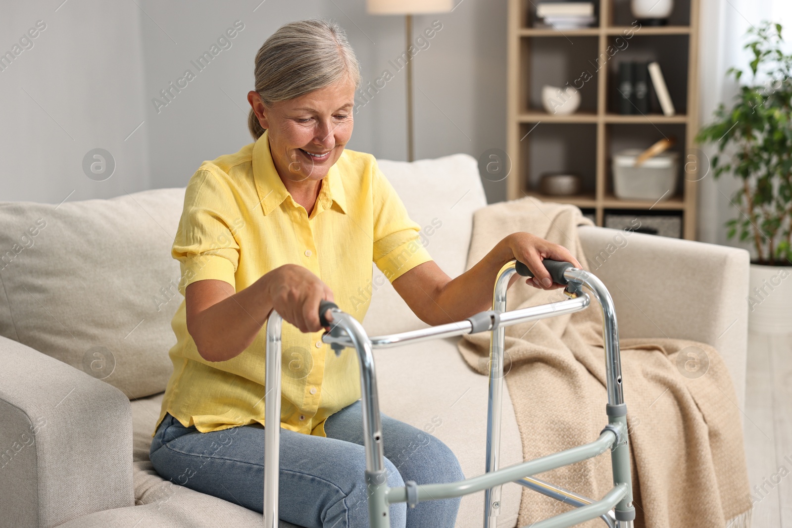 Photo of Senior woman with walking frame on sofa at home