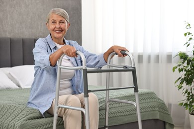 Photo of Senior woman with walking frame on bed at home