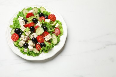 Photo of Delicious salad with feta cheese and ingredients on white table, top view. Space for text