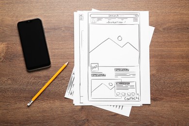 Photo of Developing UI design. Sketches of website wireframes, pencil and smartphone on wooden table, top view