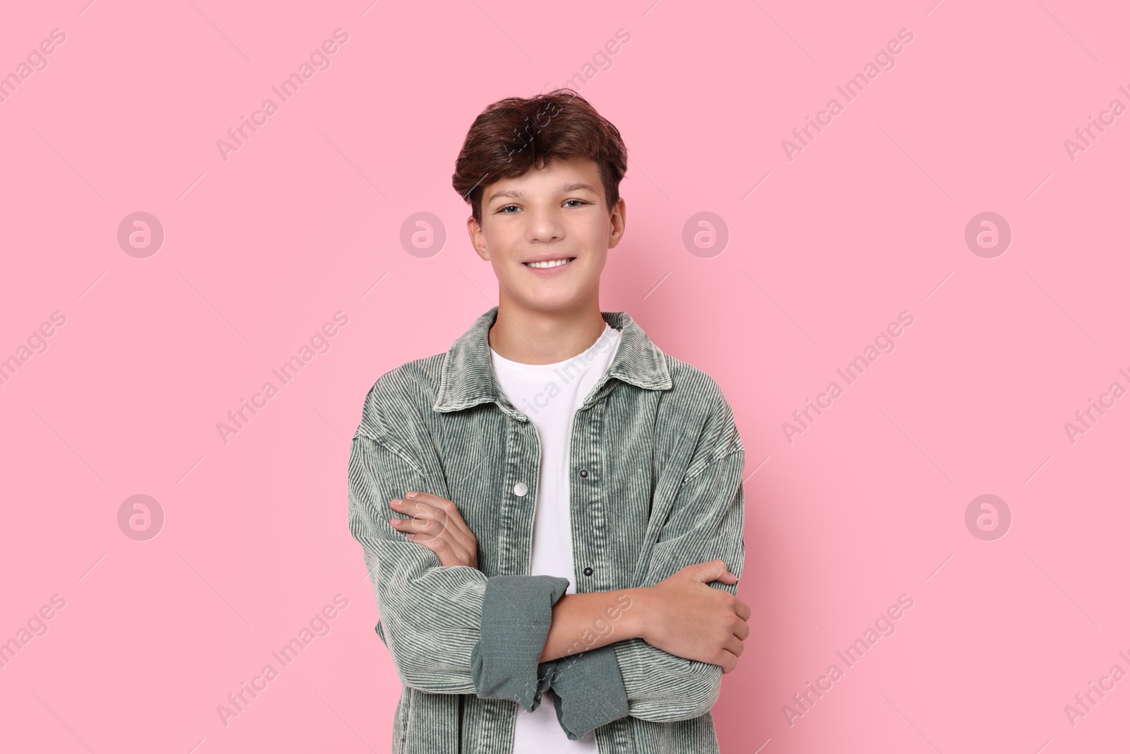 Photo of Portrait of happy teenage boy on pink background