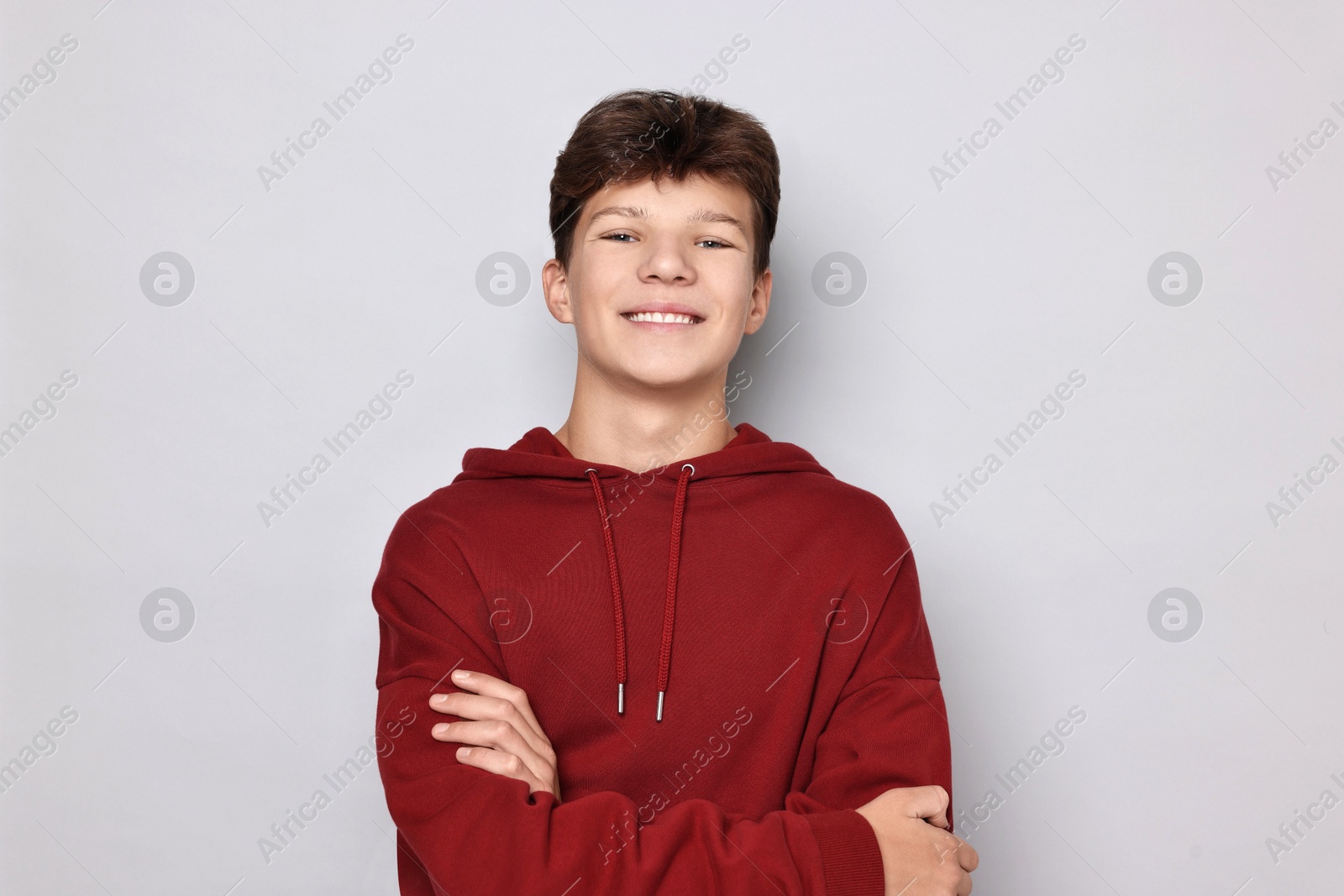 Photo of Portrait of happy teenage boy on light grey background