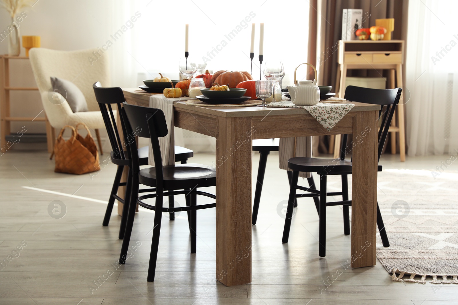 Photo of Stylish dining room with beautiful table setting and autumn decor