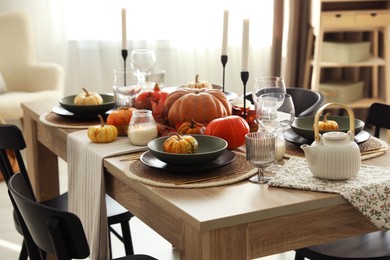 Photo of Stylish table setting with beautiful autumn decor in dining room