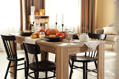 Photo of Stylish table setting with beautiful autumn decor in dining room