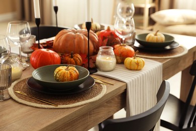 Photo of Stylish table setting with beautiful autumn decor in dining room