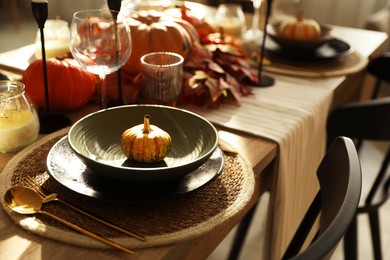 Photo of Stylish table setting with beautiful autumn decor in dining room