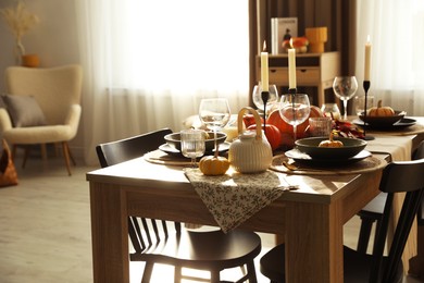 Photo of Stylish table setting with beautiful autumn decor in dining room