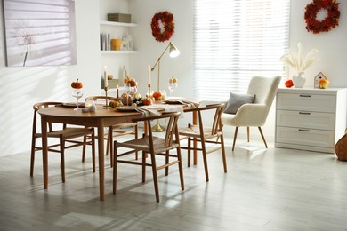 Photo of Stylish dining room with beautiful table setting and autumn decor