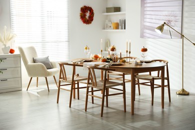 Photo of Stylish dining room with beautiful table setting and autumn decor