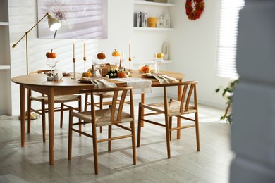 Photo of Stylish dining room with beautiful table setting and autumn decor