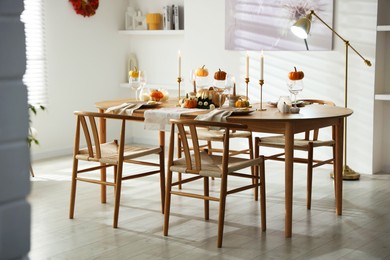 Photo of Stylish dining room with beautiful table setting and autumn decor