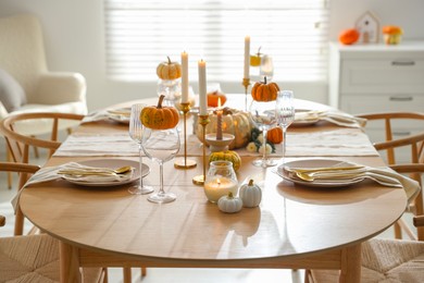 Photo of Stylish dining room with beautiful table setting and autumn decor