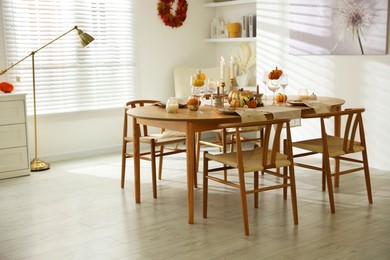 Photo of Stylish dining room with beautiful table setting and autumn decor