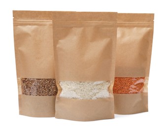 Photo of Paper pouch bags with buckwheat, rice and lentil isolated on white