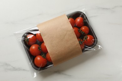 Pack of fresh tomatoes on white marble table, top view