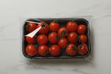 Photo of Pack of fresh tomatoes on white marble table, top view