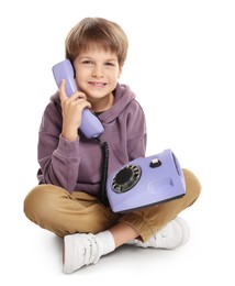 Photo of Cute little boy with old telephone on white background