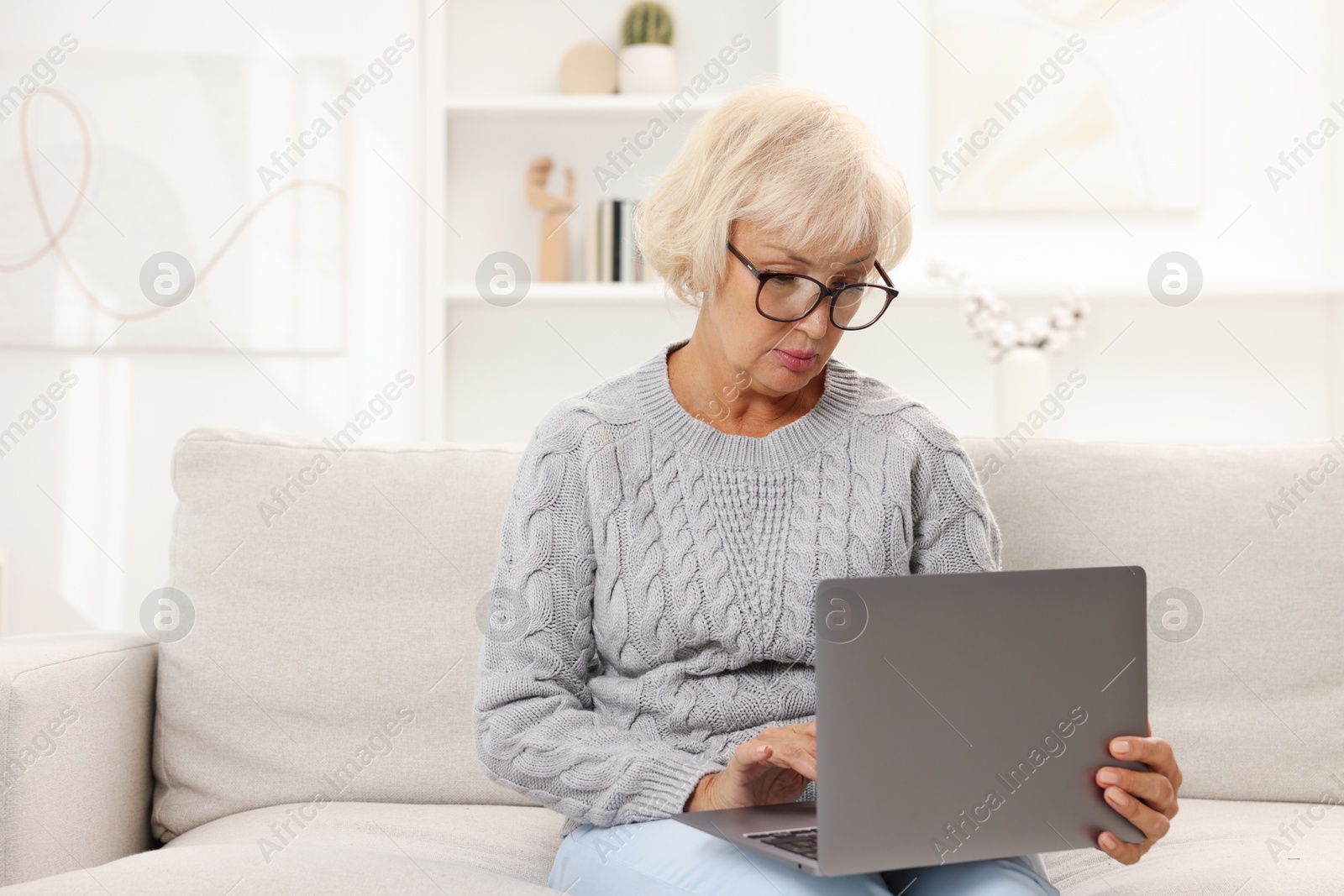 Photo of Beautiful senior woman using laptop at home