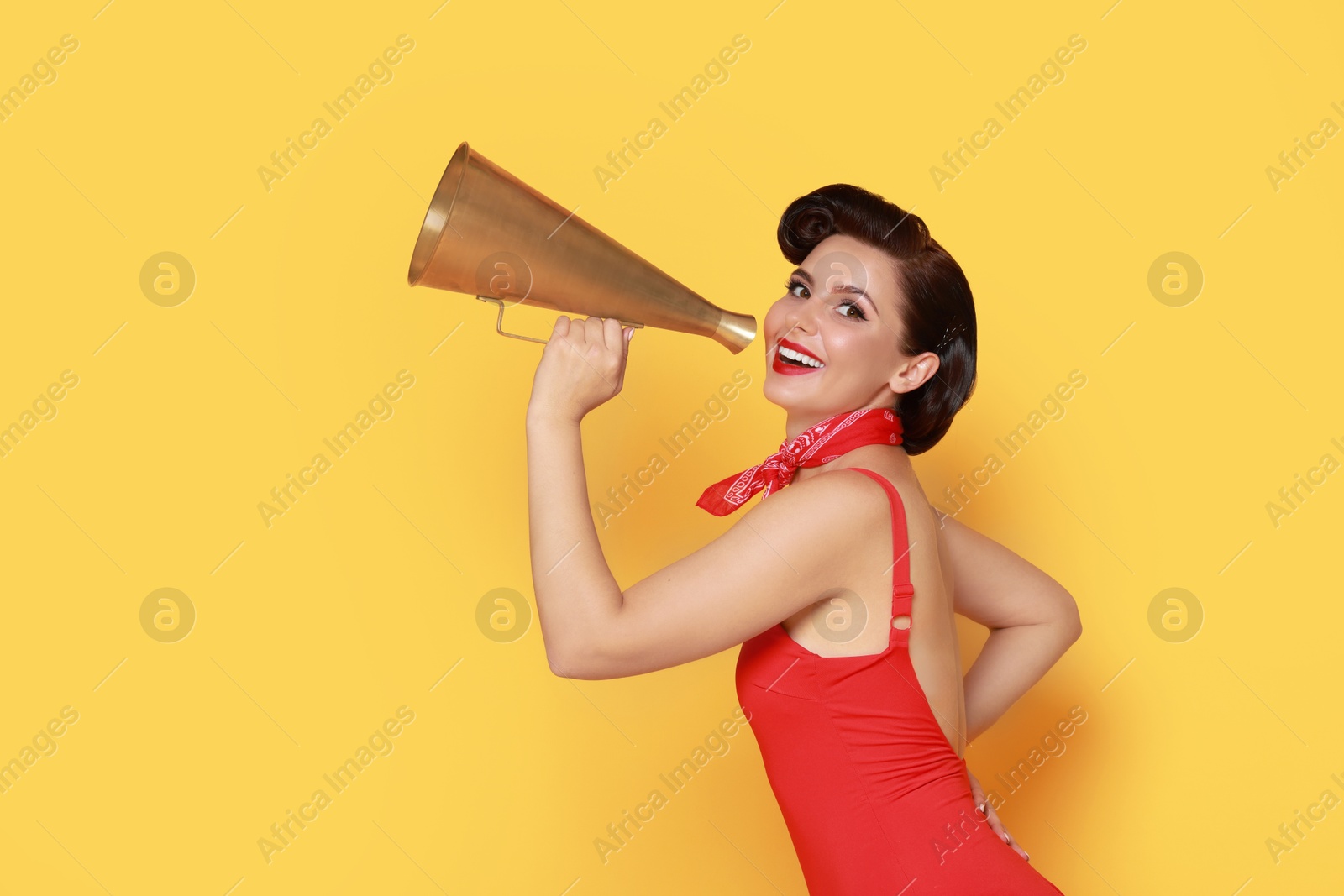 Photo of Pin-up woman with megaphone speaker on orange background