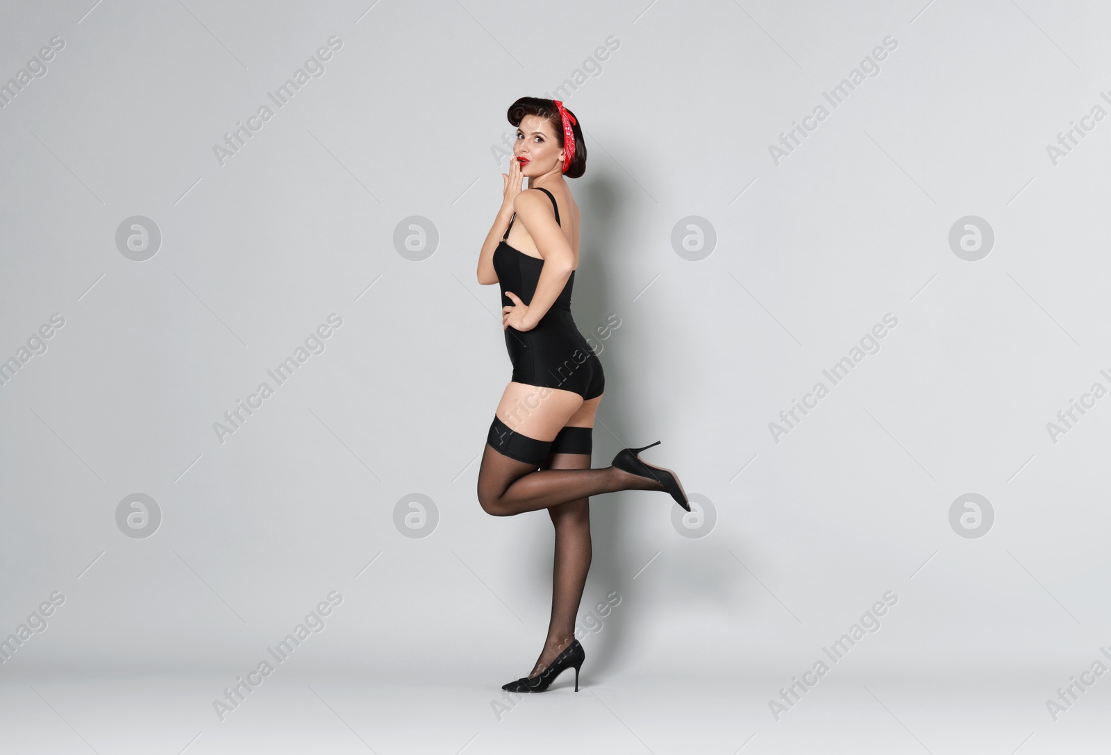 Photo of Pin-up woman in black underwear on grey background