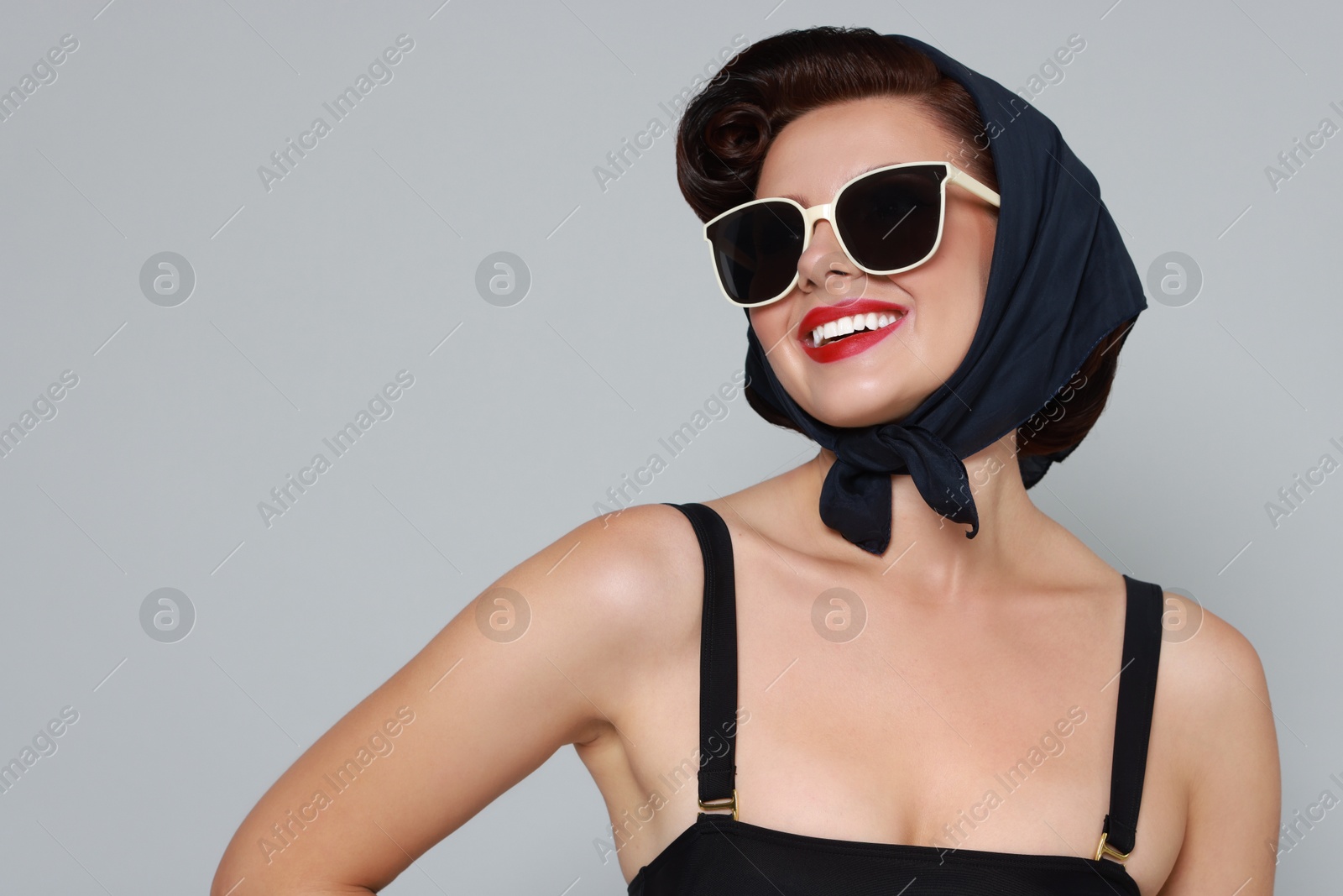 Photo of Pin-up woman in sunglasses on grey background