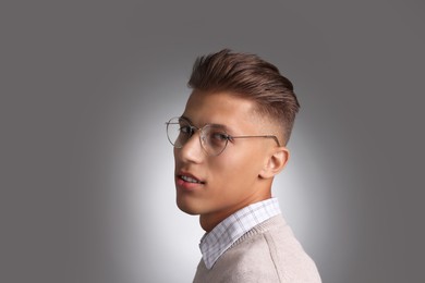 Photo of Handsome young man with stylish haircut on grey background