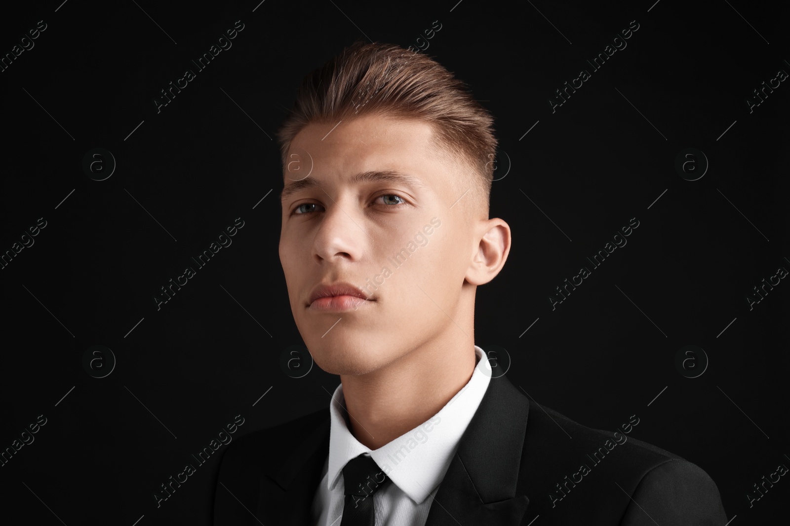 Photo of Handsome young man with stylish haircut on black background