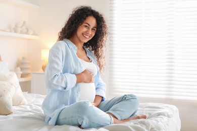 Photo of Portrait of beautiful pregnant woman on bed at home