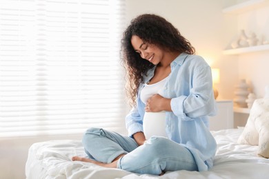 Photo of Portrait of beautiful pregnant woman on bed at home