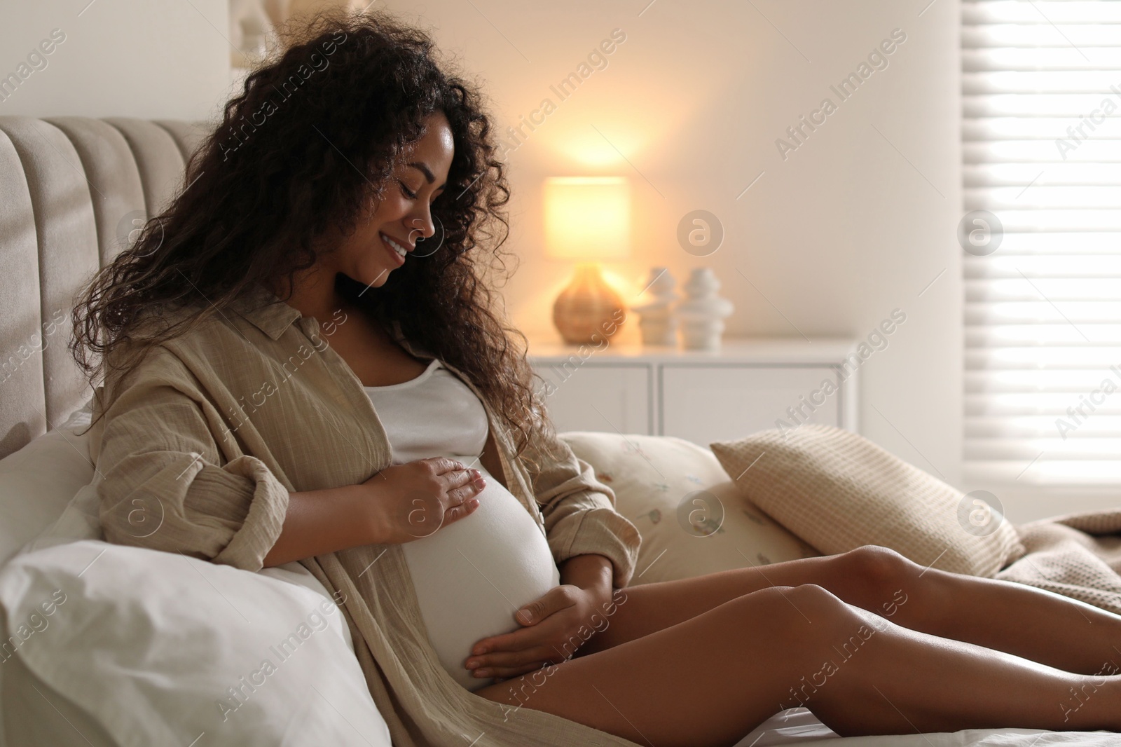 Photo of Portrait of beautiful pregnant woman on bed at home