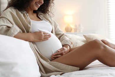 Photo of Pregnant woman on bed at home, closeup