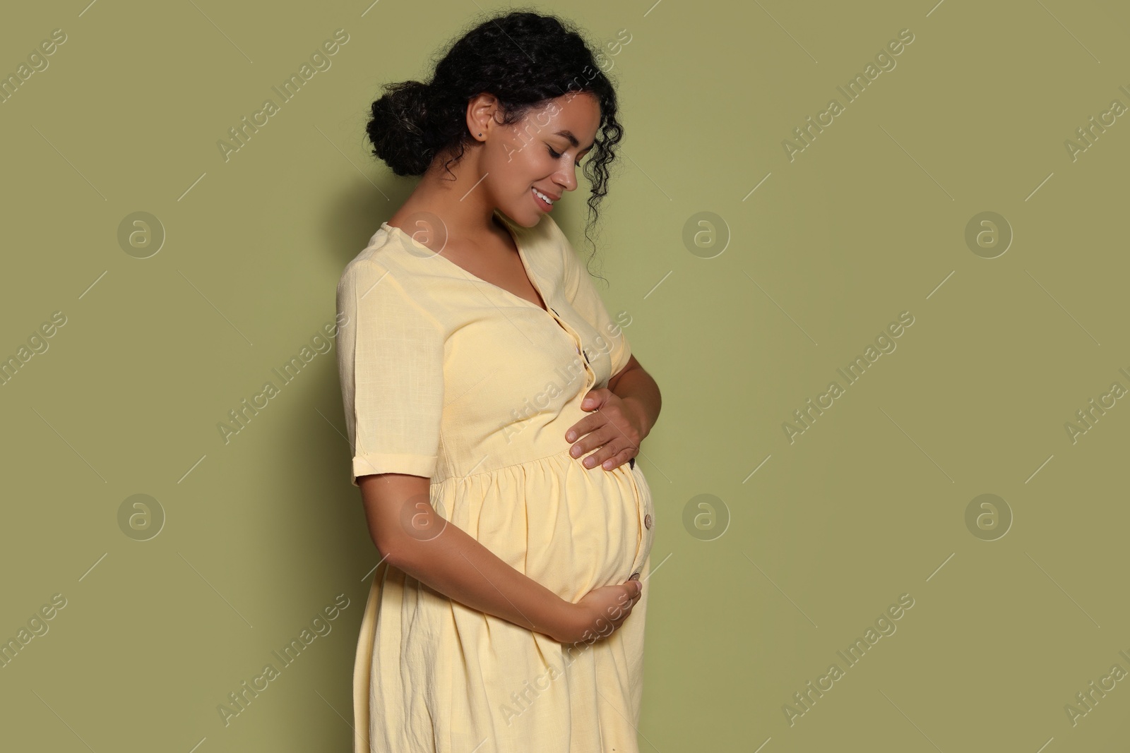 Photo of Portrait of beautiful pregnant woman on green background