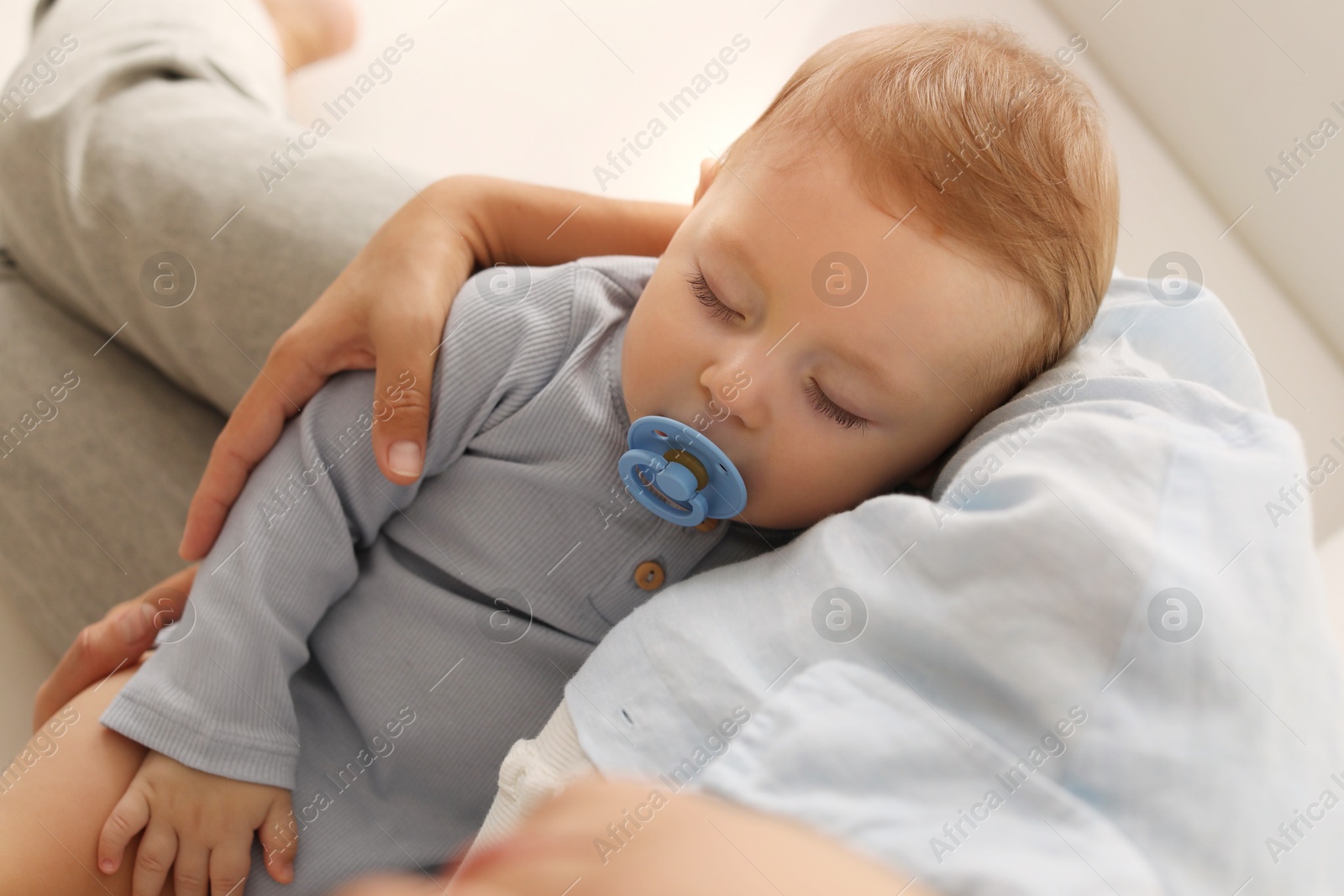 Photo of Mother with her sleeping baby on sofa indoors, closeup