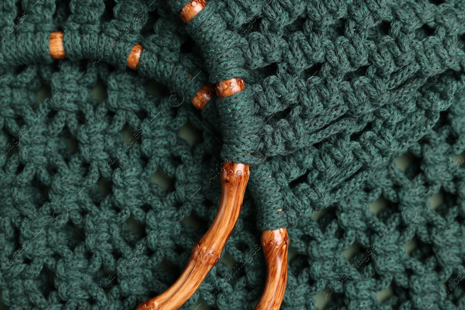 Photo of Macrame shopping bag with wooden handles as background, top view