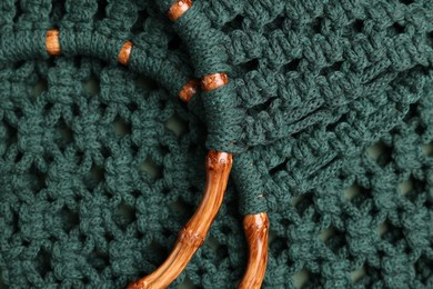 Photo of Macrame shopping bag with wooden handles as background, top view