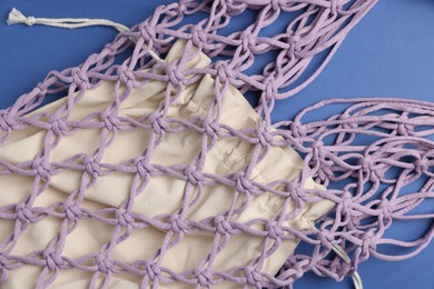 Photo of Macrame shopping bag on blue background, above view