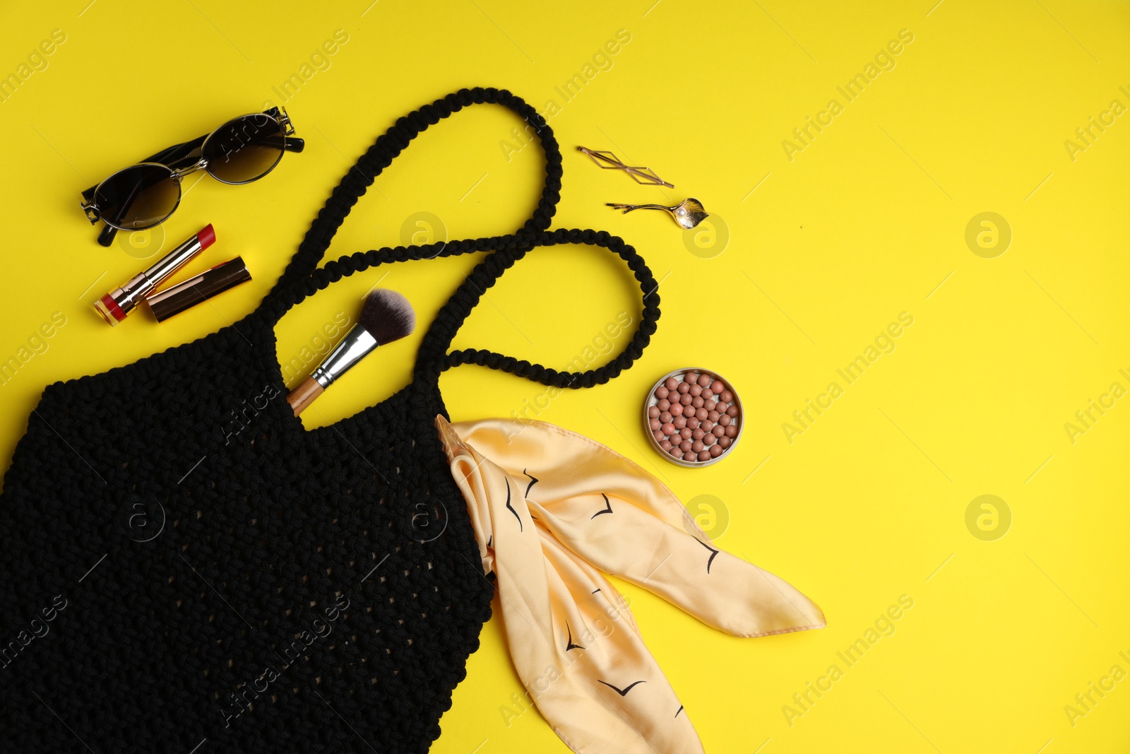 Photo of Flat lay composition with macrame shopping bag and makeup products on yellow background. Space for text