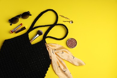 Photo of Flat lay composition with macrame shopping bag and makeup products on yellow background. Space for text