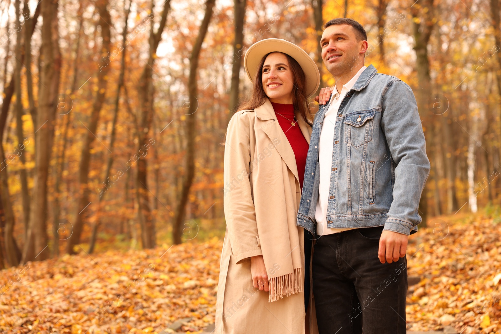 Photo of Happy couple spending time together in autumn park, space for text