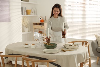 Photo of Woman setting table for dinner at home