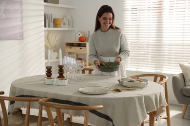 Photo of Woman setting table for dinner at home