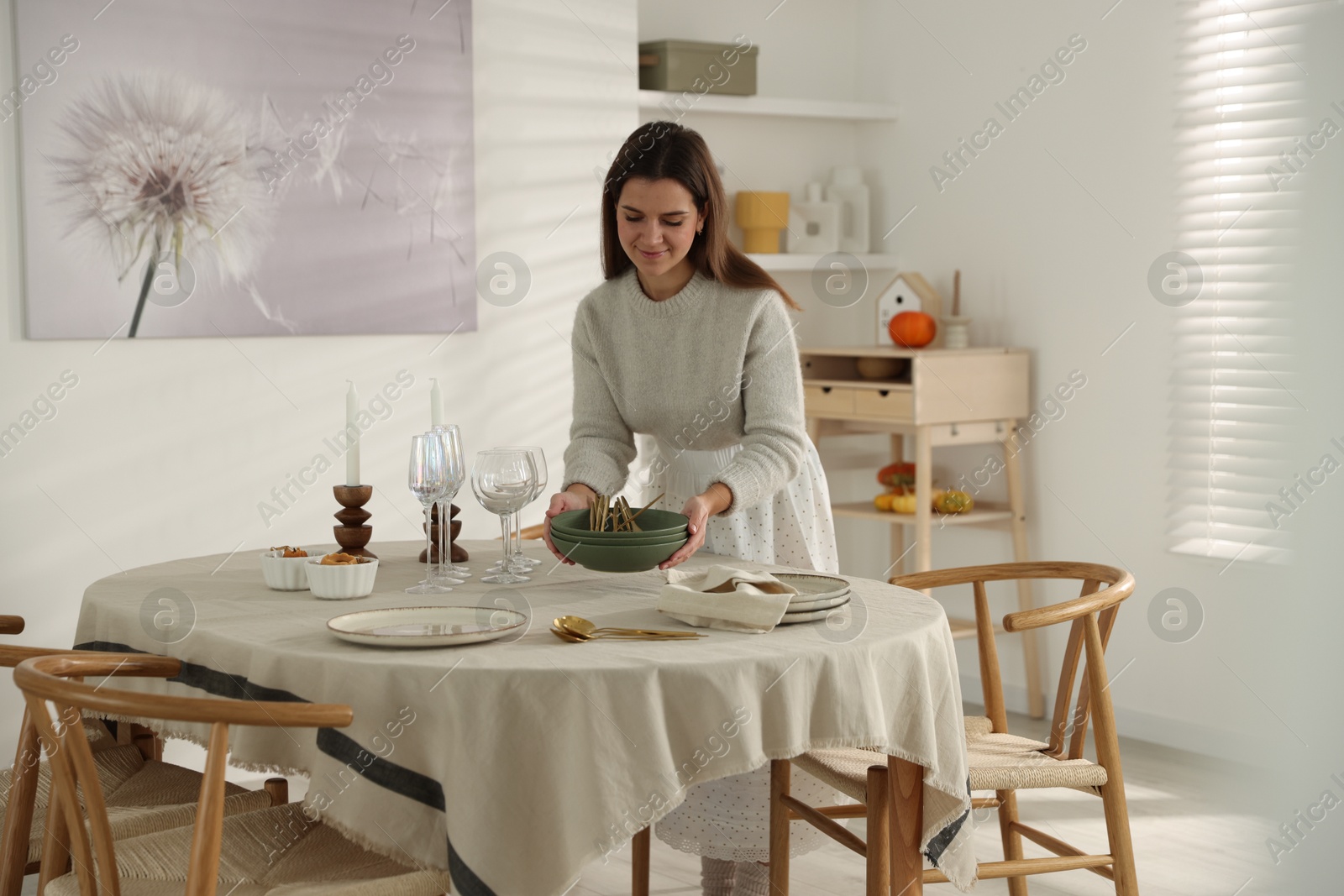 Photo of Woman setting table for dinner at home