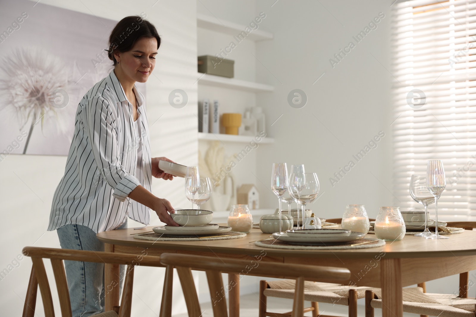 Photo of Woman setting table for dinner at home