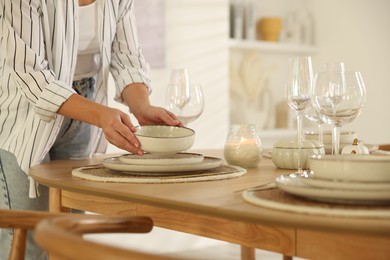 Photo of Woman setting table for dinner at home, closeup