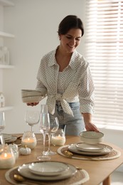 Photo of Woman setting table for dinner at home