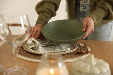 Photo of Woman setting table for dinner at home, closeup