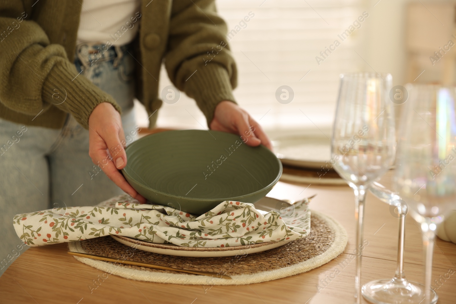 Photo of Woman setting table for dinner at home, closeup