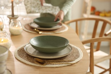 Photo of Woman setting table for dinner at home, closeup