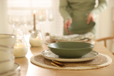 Photo of Woman setting table for dinner at home, closeup